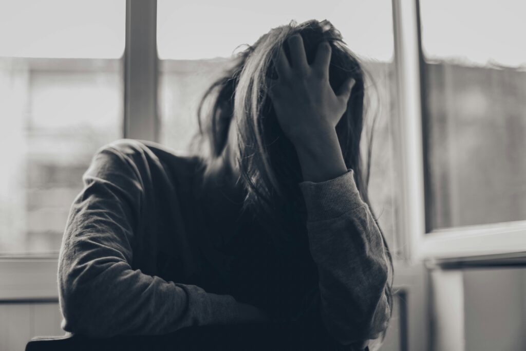 Despair - girl with head in her hands in black and white